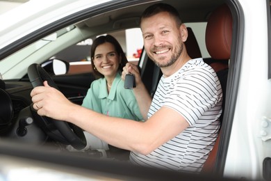 Photo of Happy family with keys inside new car
