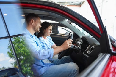 Photo of Happy family sitting inside new car. Luxury vehicle