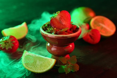 Photo of Hookah bowl with limes, strawberries, mint and smoke on black table, closeup