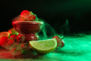 Photo of Hookah bowl with limes, strawberries, mint and smoke on black table, closeup. Space for text