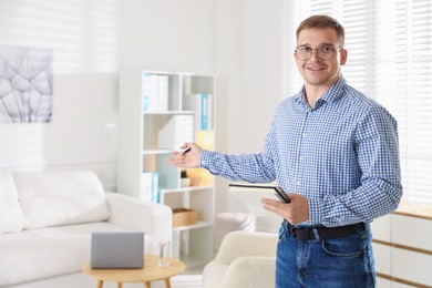Photo of Smiling psychologist in glasses inviting to sofa in office