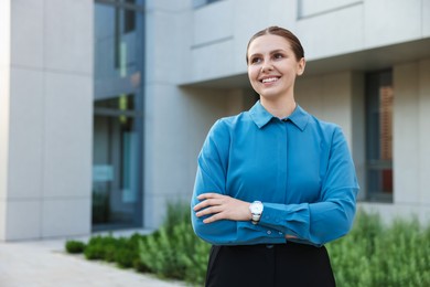 Photo of Portrait of happy businesswoman near office building. Space for text
