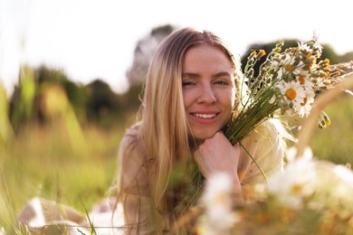 Photo of Beautiful woman with wildflowers in meadow on sunny day