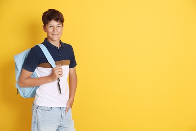 Photo of Teenage boy with backpack on orange background, space for text