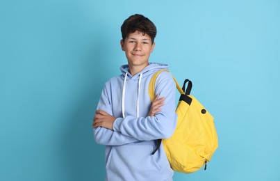Photo of Teenage boy with backpack on light blue background