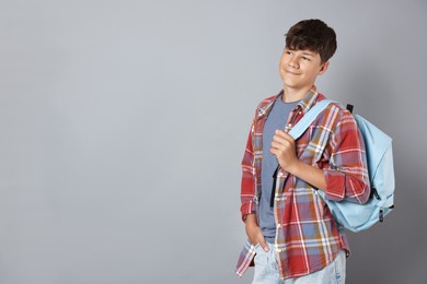 Photo of Teenage boy with backpack on grey background, space for text
