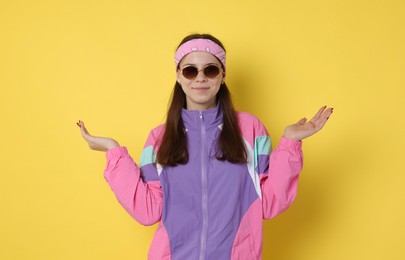 Photo of Teenage girl in sunglasses on yellow background