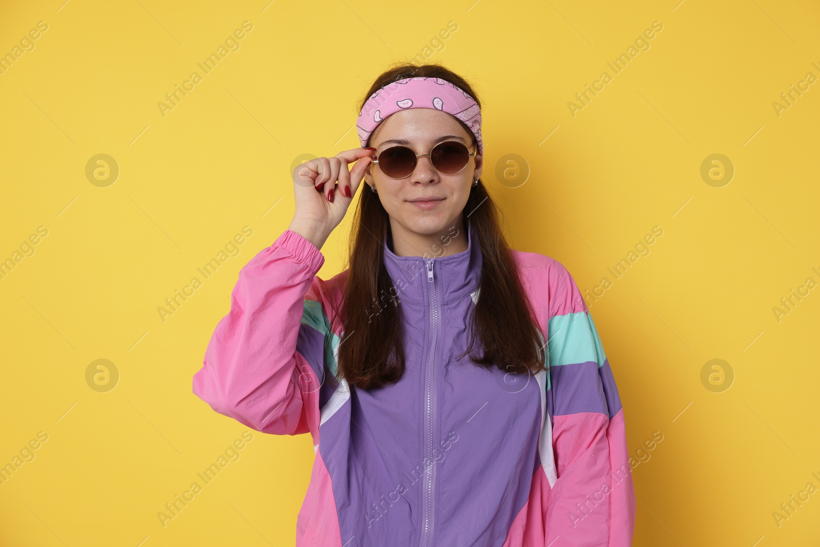 Teenage girl in sunglasses on yellow background Photo of Teenage girl in sunglasses on yellow background