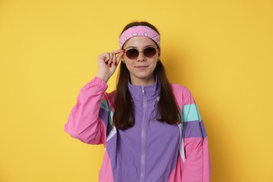 Photo of Teenage girl in sunglasses on yellow background