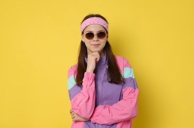 Photo of Teenage girl in sunglasses on yellow background