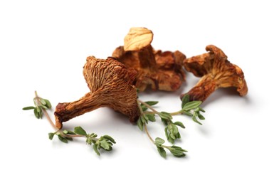 Photo of Dried chanterelle mushrooms and thyme isolated on white