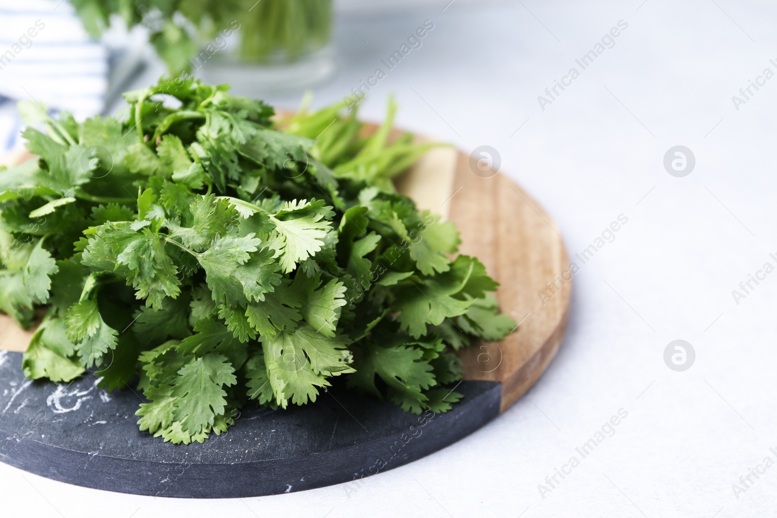 Photo of Fresh green cilantro on light table, closeup. Space for text