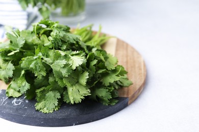 Photo of Fresh green cilantro on light table, closeup. Space for text