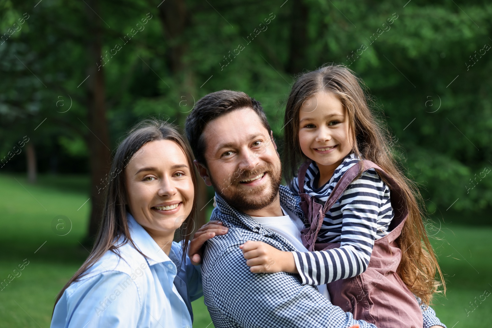 Family portrait of smiling parents and daughter outdoors Photo of Family portrait of smiling parents and daughter outdoors