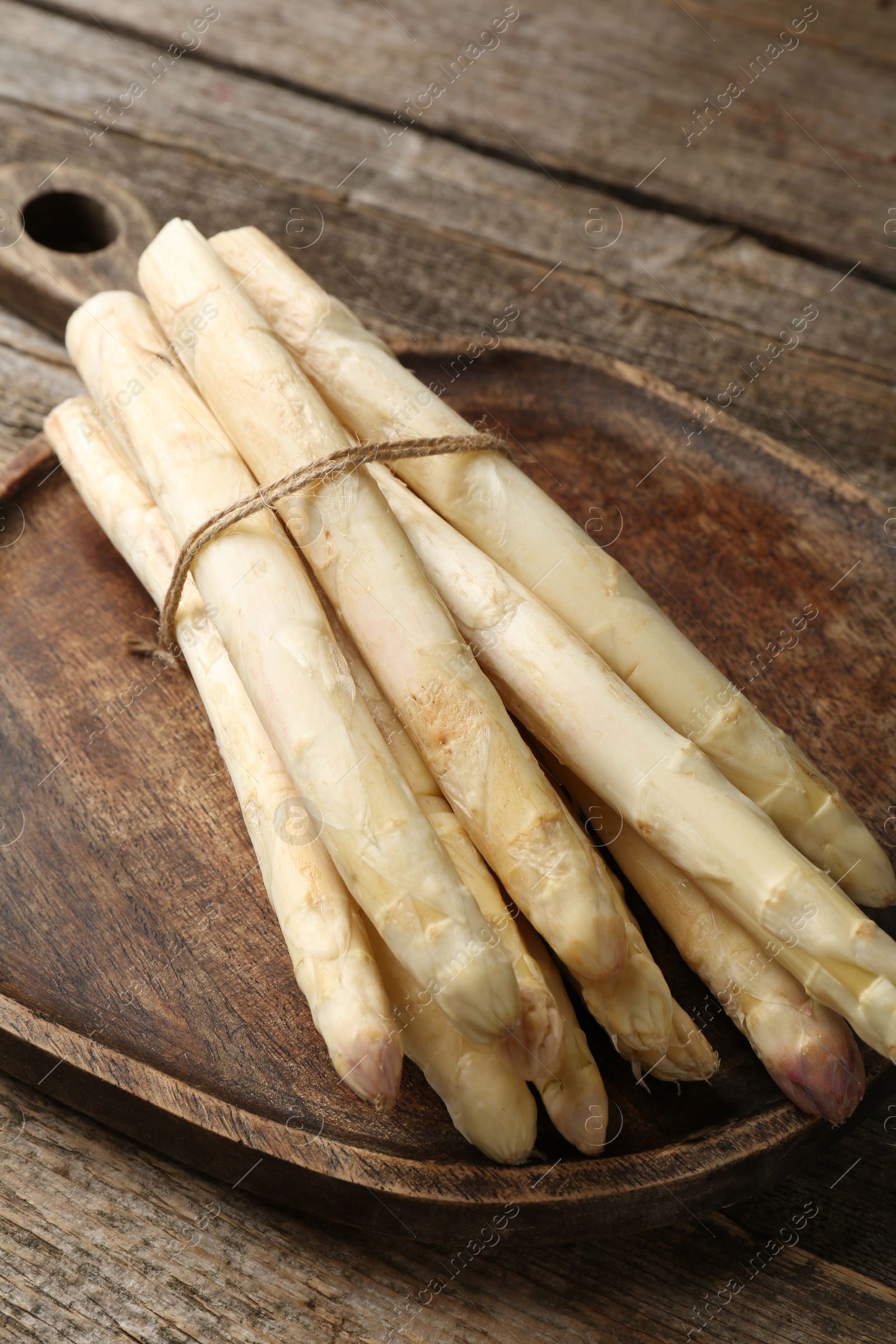 Raw white asparagus spears on wooden table, closeup Photo of Raw white asparagus spears on wooden table, closeup