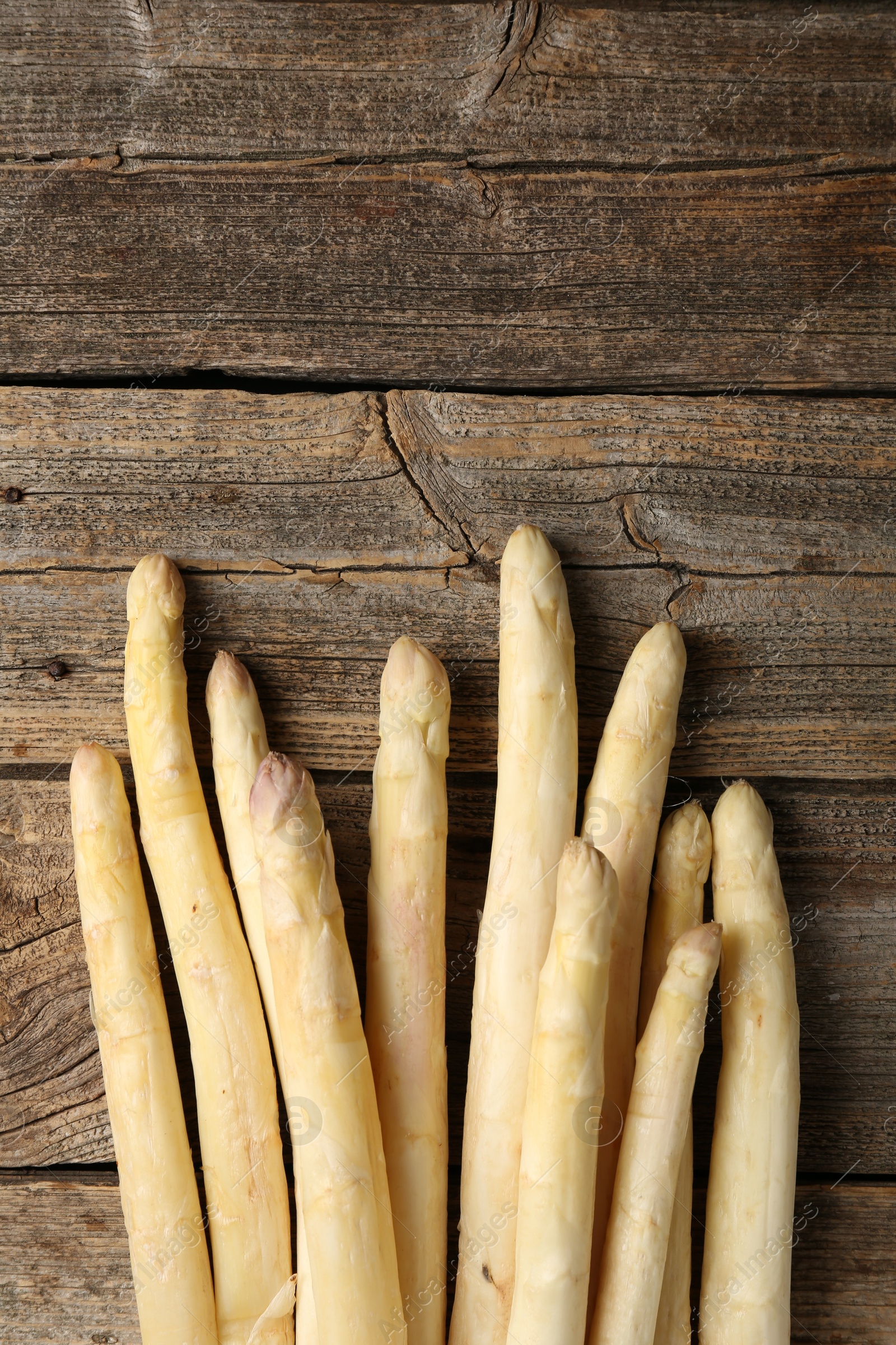 Raw white asparagus spears on wooden table, flat lay. Space for text Photo of Raw white asparagus spears on wooden table, flat lay. Space for text