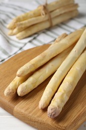 Photo of Raw asparagus spears on white wooden table, closeup