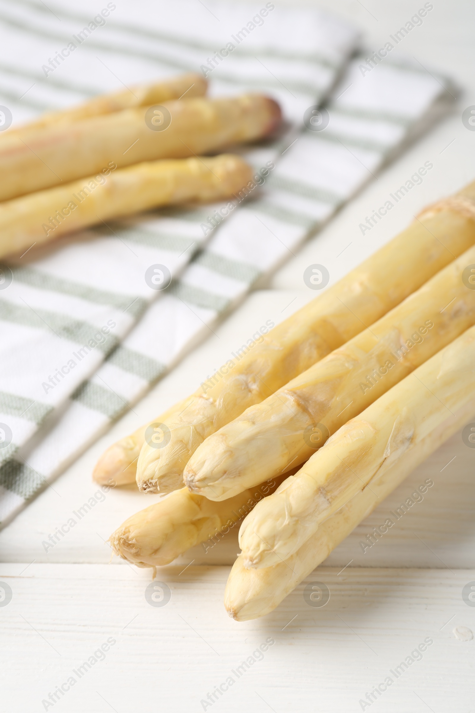 Raw asparagus spears on white wooden table, closeup Photo of Raw asparagus spears on white wooden table, closeup