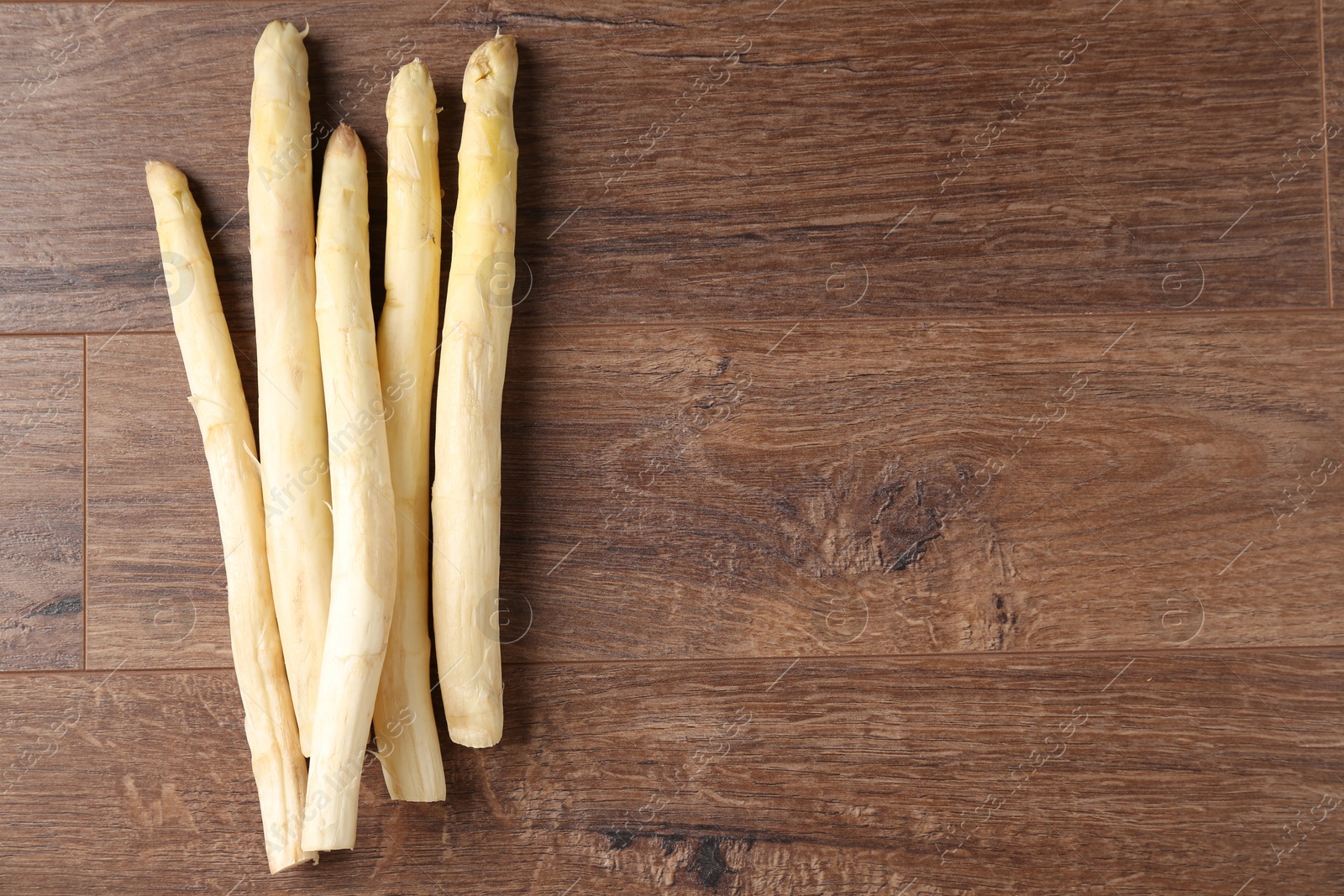 Raw white asparagus spears on wooden table, flat lay. Space for text Photo of Raw white asparagus spears on wooden table, flat lay. Space for text