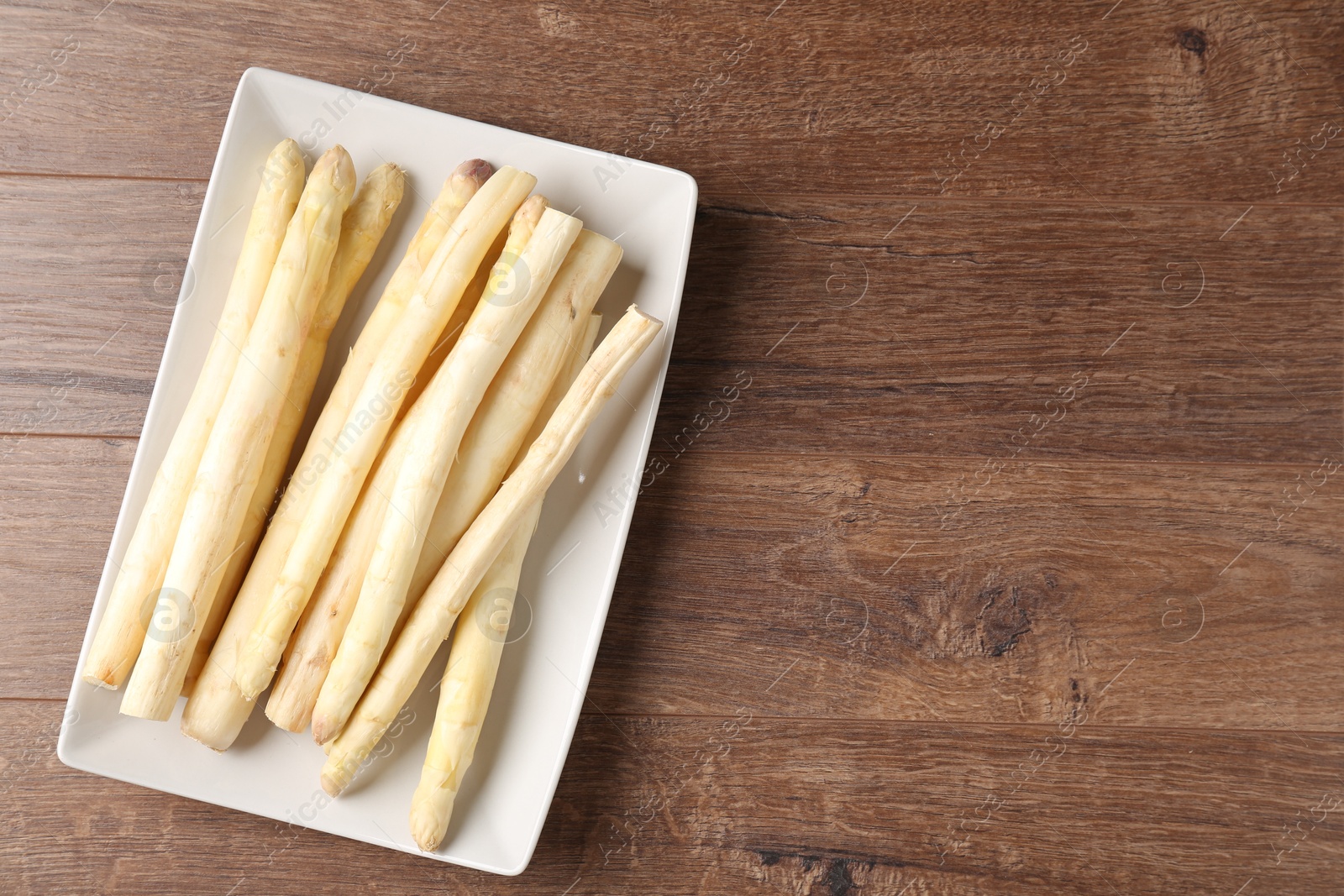 Raw white asparagus spears on wooden table, top view. Space for text Photo of Raw white asparagus spears on wooden table, top view. Space for text
