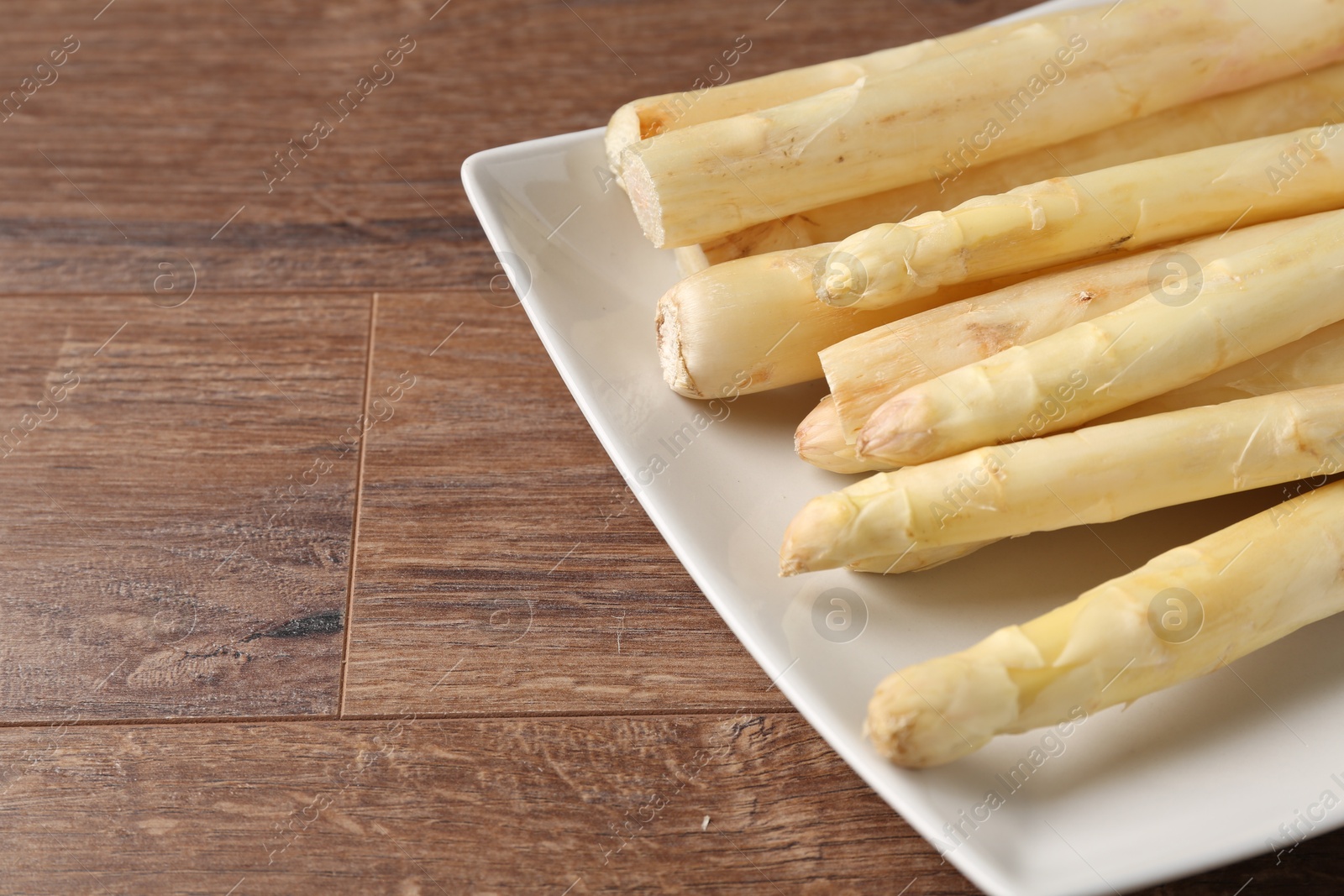 Raw white asparagus spears on wooden table, closeup. Space for text Photo of Raw white asparagus spears on wooden table, closeup. Space for text
