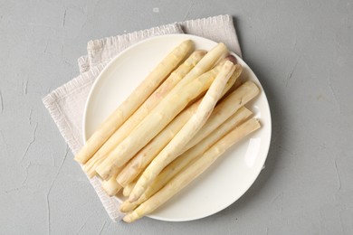 Photo of Raw white asparagus spears on grey textured table, top view
