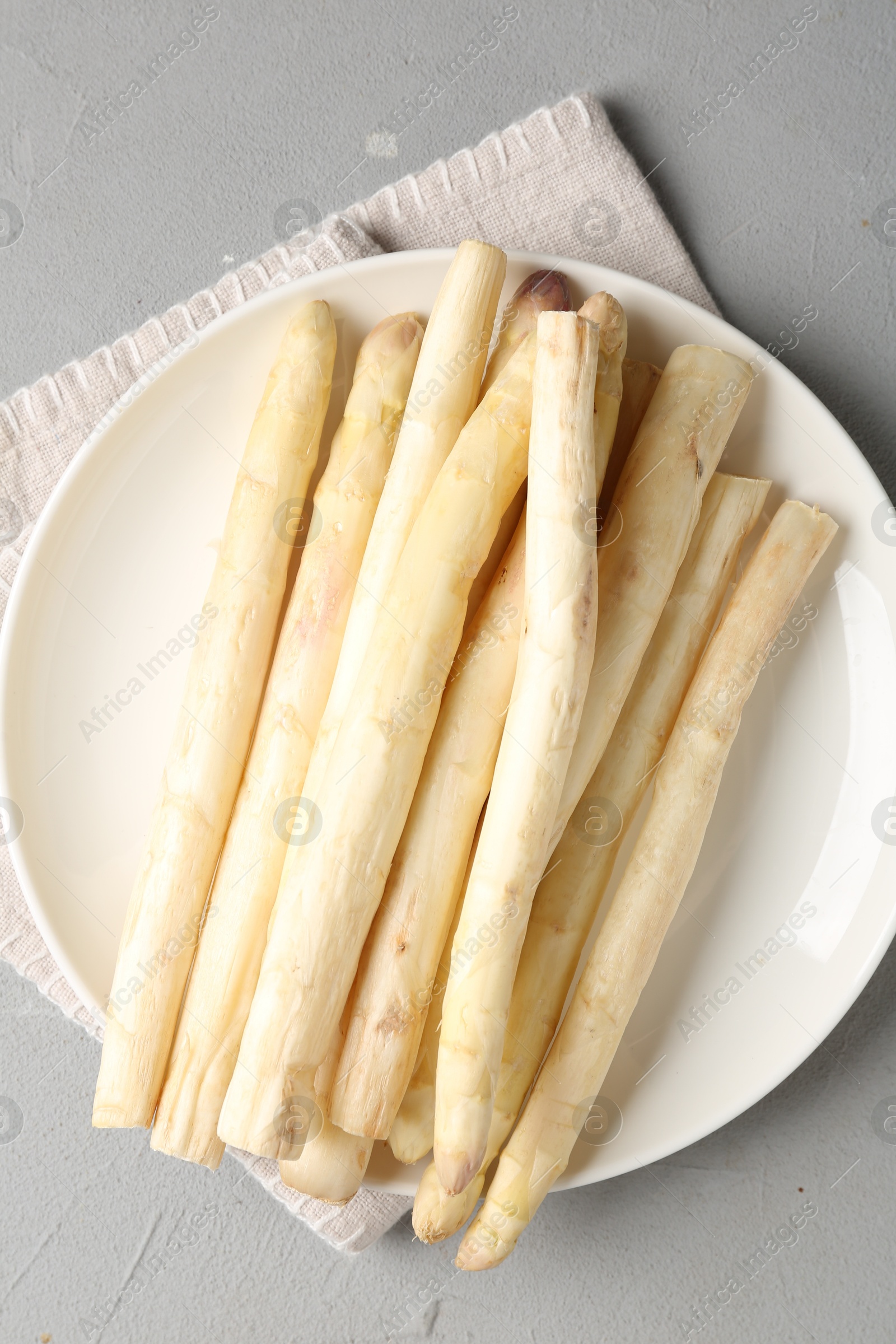 Raw white asparagus spears on grey textured table, top view Photo of Raw white asparagus spears on grey textured table, top view