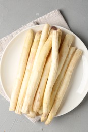 Photo of Raw white asparagus spears on grey textured table, top view