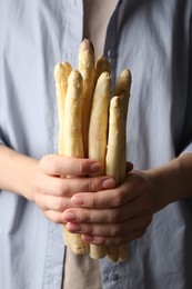 Photo of Woman with raw white asparagus spears, closeup