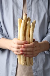 Photo of Woman with raw white asparagus spears, closeup