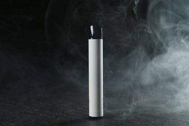 Photo of Modern electronic smoking device on black table