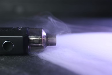Photo of Modern electronic smoking device on black table, closeup. Space for text
