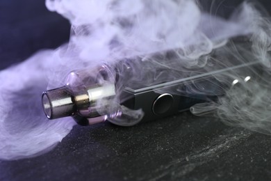 Photo of Modern electronic smoking device on black table, closeup