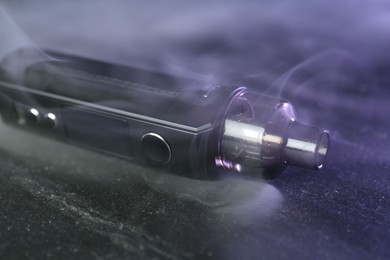 Photo of Modern electronic smoking device on black table, closeup