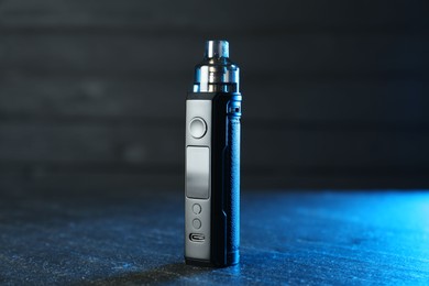Photo of Modern electronic smoking device on black table
