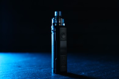 Photo of Modern electronic smoking device on black table