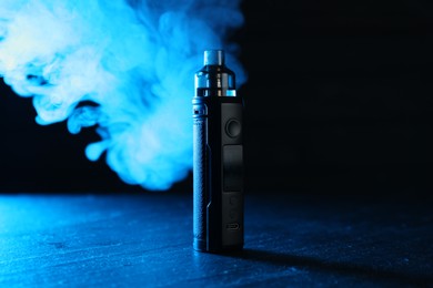 Photo of Electronic smoking device on black table in blue light