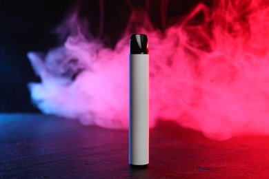Photo of Electronic smoking device on black table in red light
