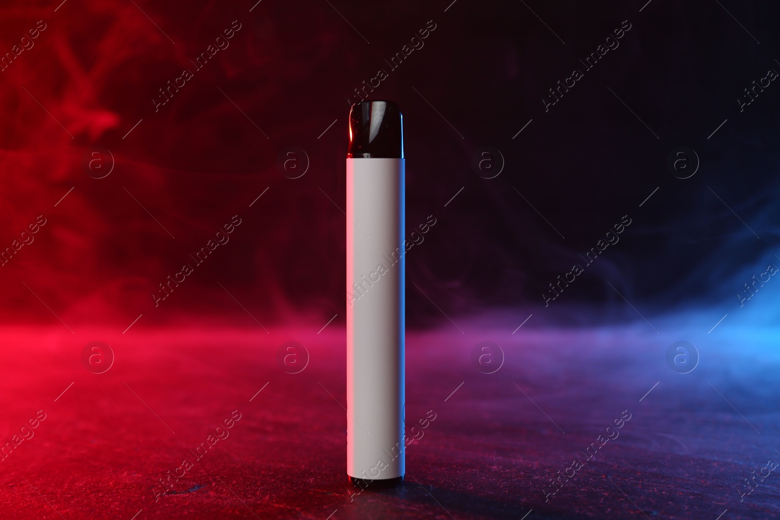Electronic smoking device on black table in red light Photo of Electronic smoking device on black table in red light