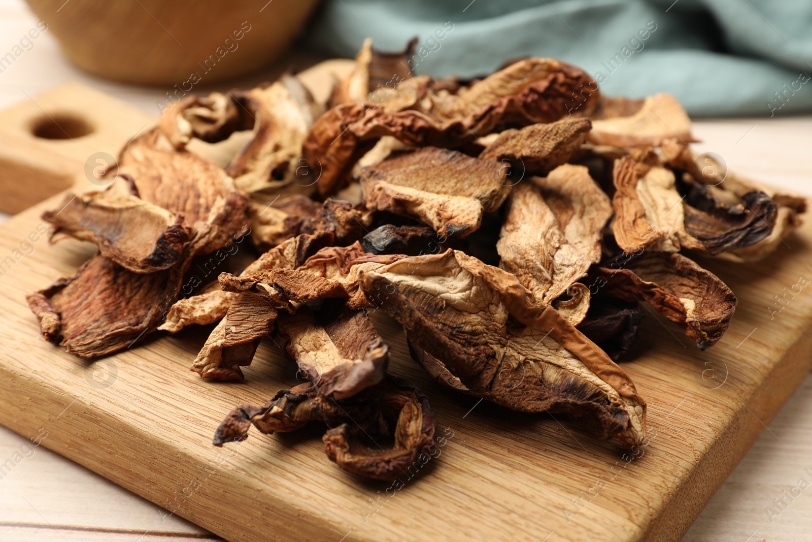 Pieces of dried mushrooms on light wooden table, closeup Photo of Pieces of dried mushrooms on light wooden table, closeup
