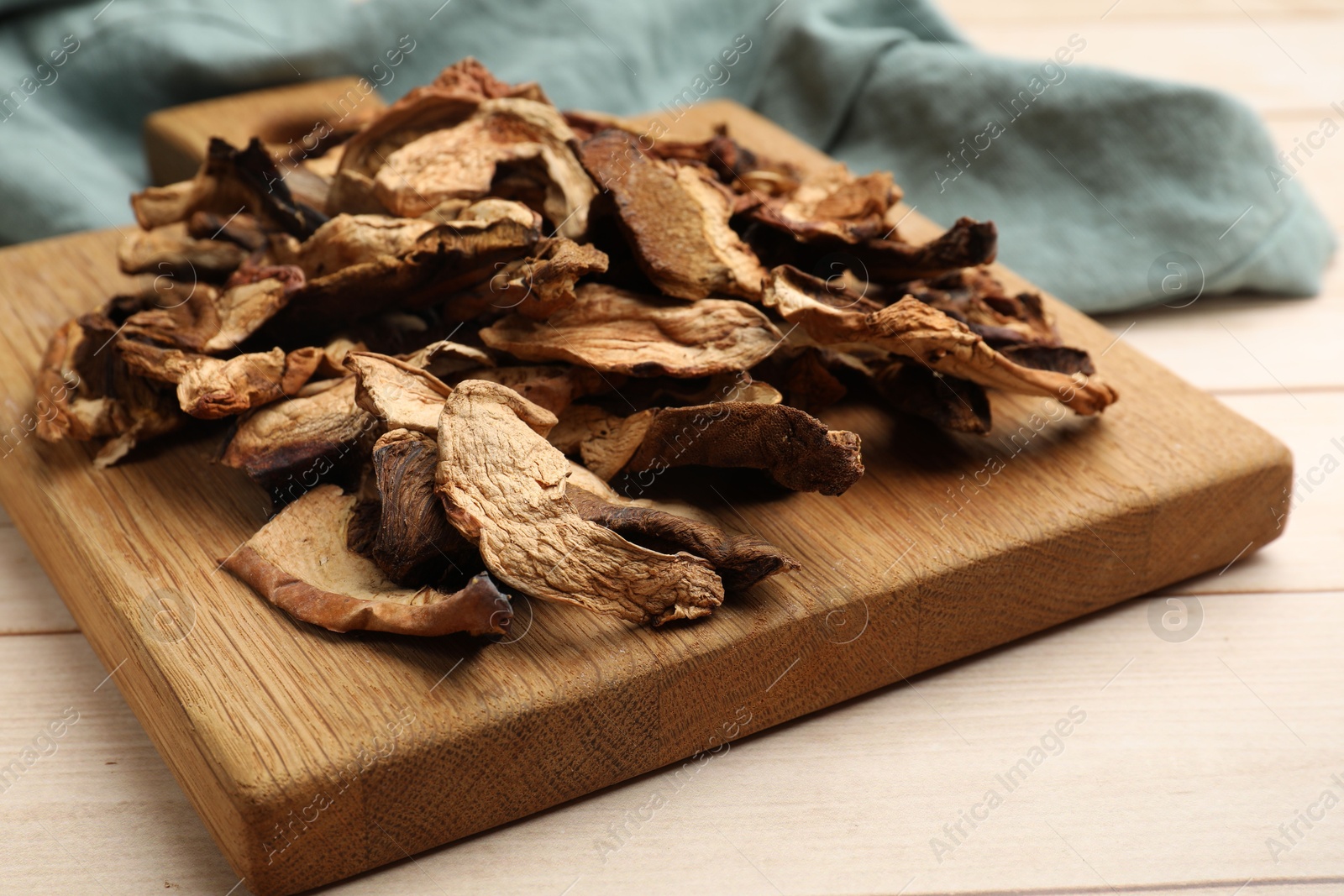 Pieces of dried mushrooms on light wooden table, closeup Photo of Pieces of dried mushrooms on light wooden table, closeup