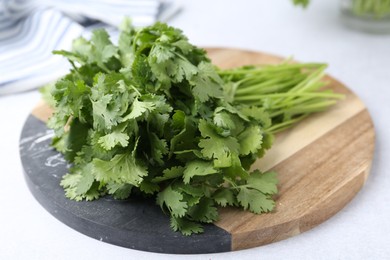 Photo of Fresh green cilantro on light table, closeup