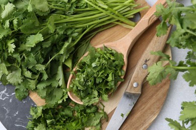 Photo of Fresh green cilantro and knife on light table, top view