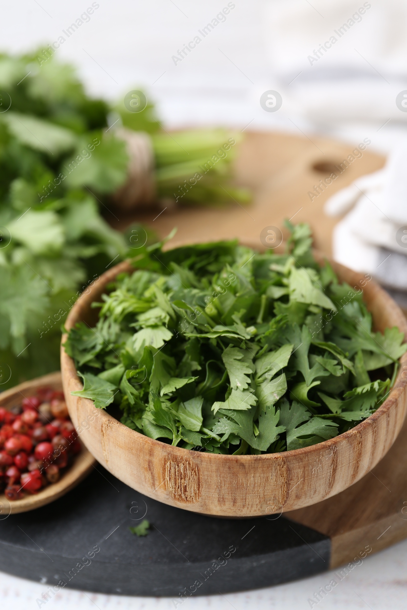 Photo of Fresh green cilantro and peppercorns on table, closeup