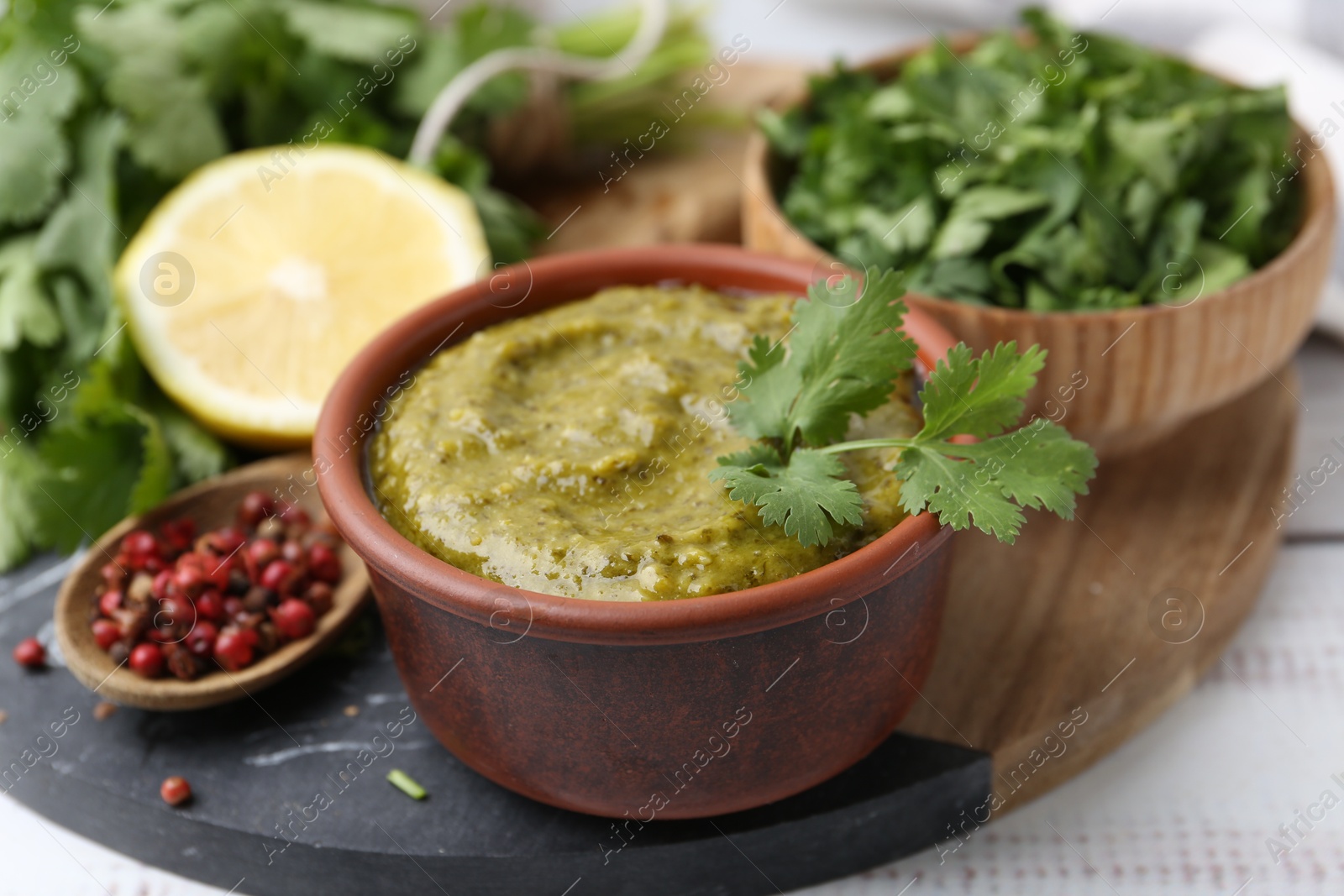 Tasty sauce with cilantro and other ingredients on white wooden table, closeup Photo of Tasty sauce with cilantro and other ingredients on white wooden table, closeup