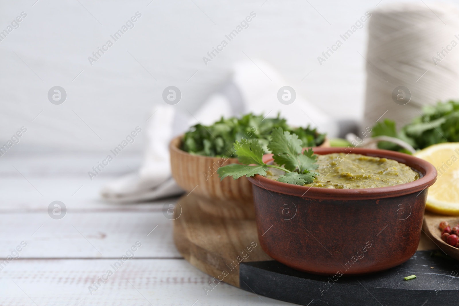 Tasty sauce with cilantro and other ingredients on white wooden table, closeup. Space for text Photo of Tasty sauce with cilantro and other ingredients on white wooden table, closeup. Space for text