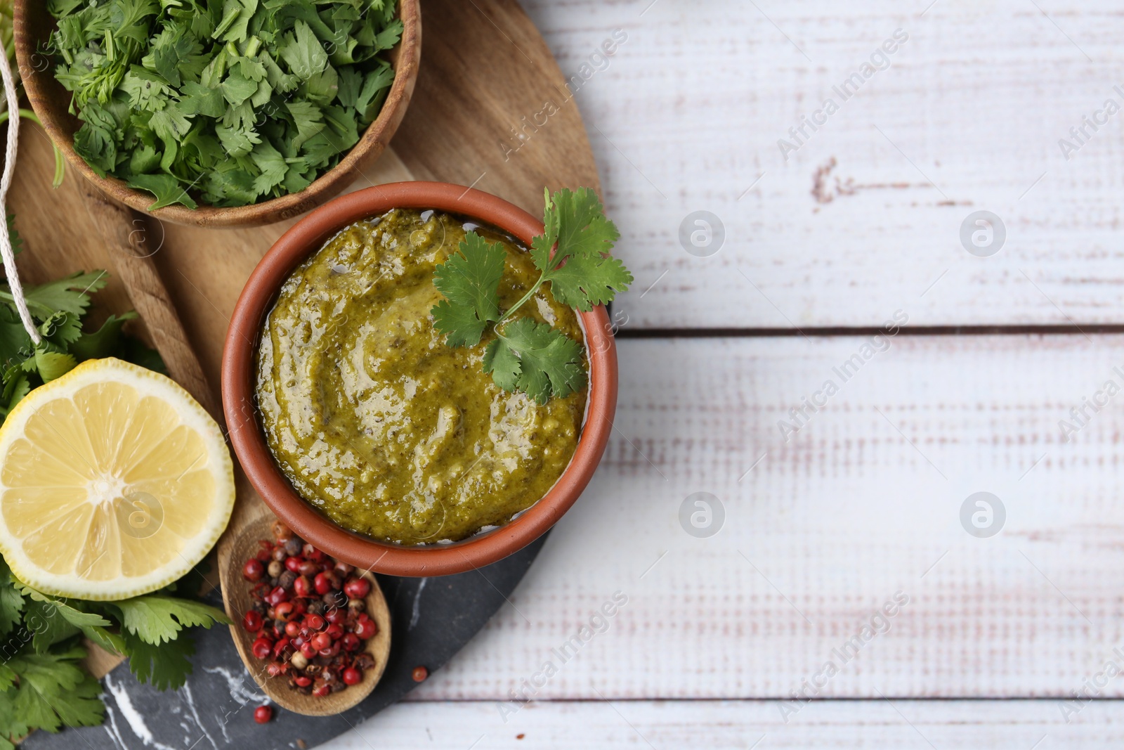 Tasty sauce with cilantro and other ingredients on white wooden table, top view. Space for text Photo of Tasty sauce with cilantro and other ingredients on white wooden table, top view. Space for text