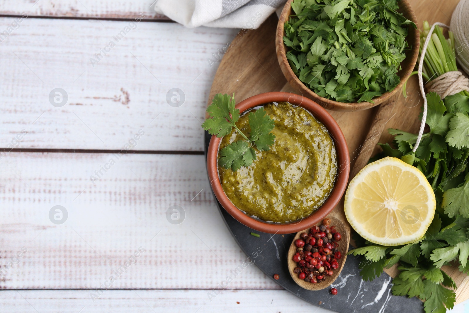Tasty sauce with cilantro and other ingredients on white wooden table, top view. Space for text Photo of Tasty sauce with cilantro and other ingredients on white wooden table, top view. Space for text