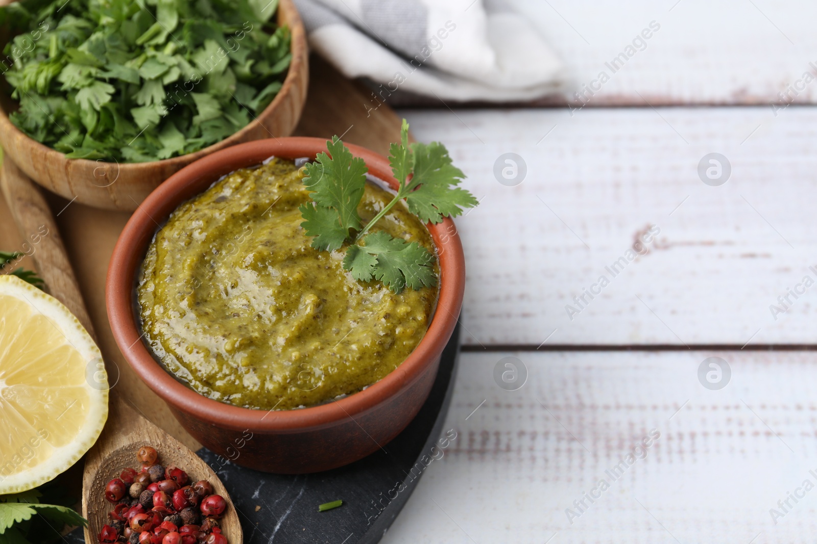 Tasty sauce with cilantro and other ingredients on white wooden table, closeup. Space for text Photo of Tasty sauce with cilantro and other ingredients on white wooden table, closeup. Space for text