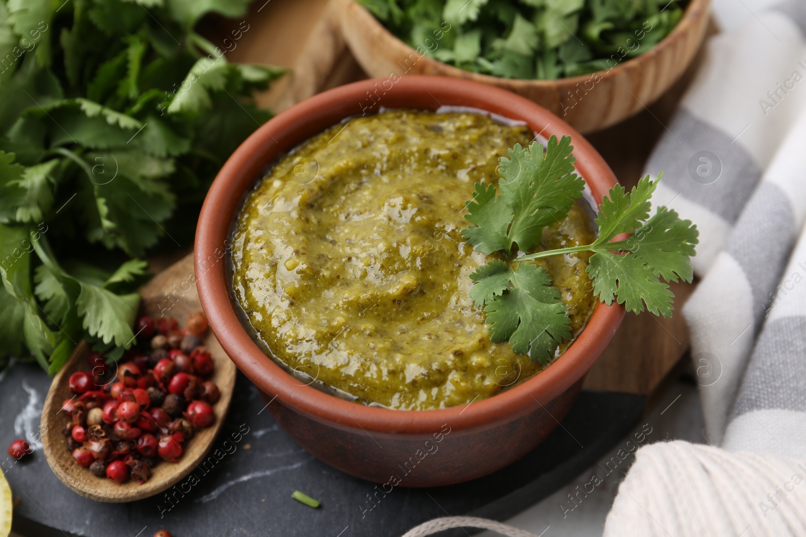 Tasty sauce with cilantro and other ingredients on table, closeup Photo of Tasty sauce with cilantro and other ingredients on table, closeup